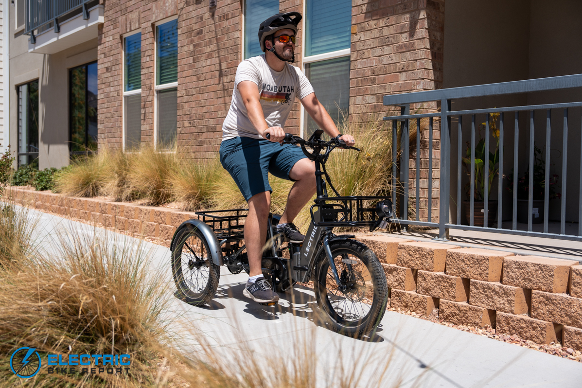 man riding Lectric XP Trike on a sidewalk