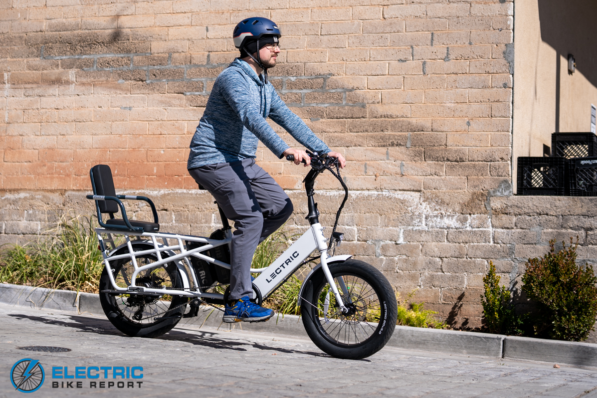 Man riding the Lectric XPedition in front of a brick wall